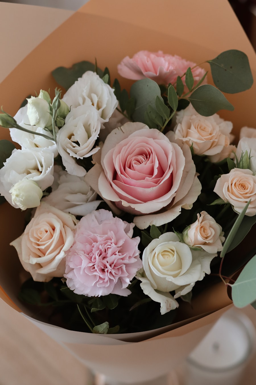 Pastel roses and carnations wrapped in peach kraft paper