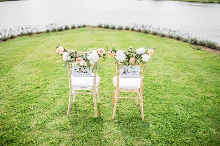 Two wedding chairs dressed with garlands of peach roses and greenery
